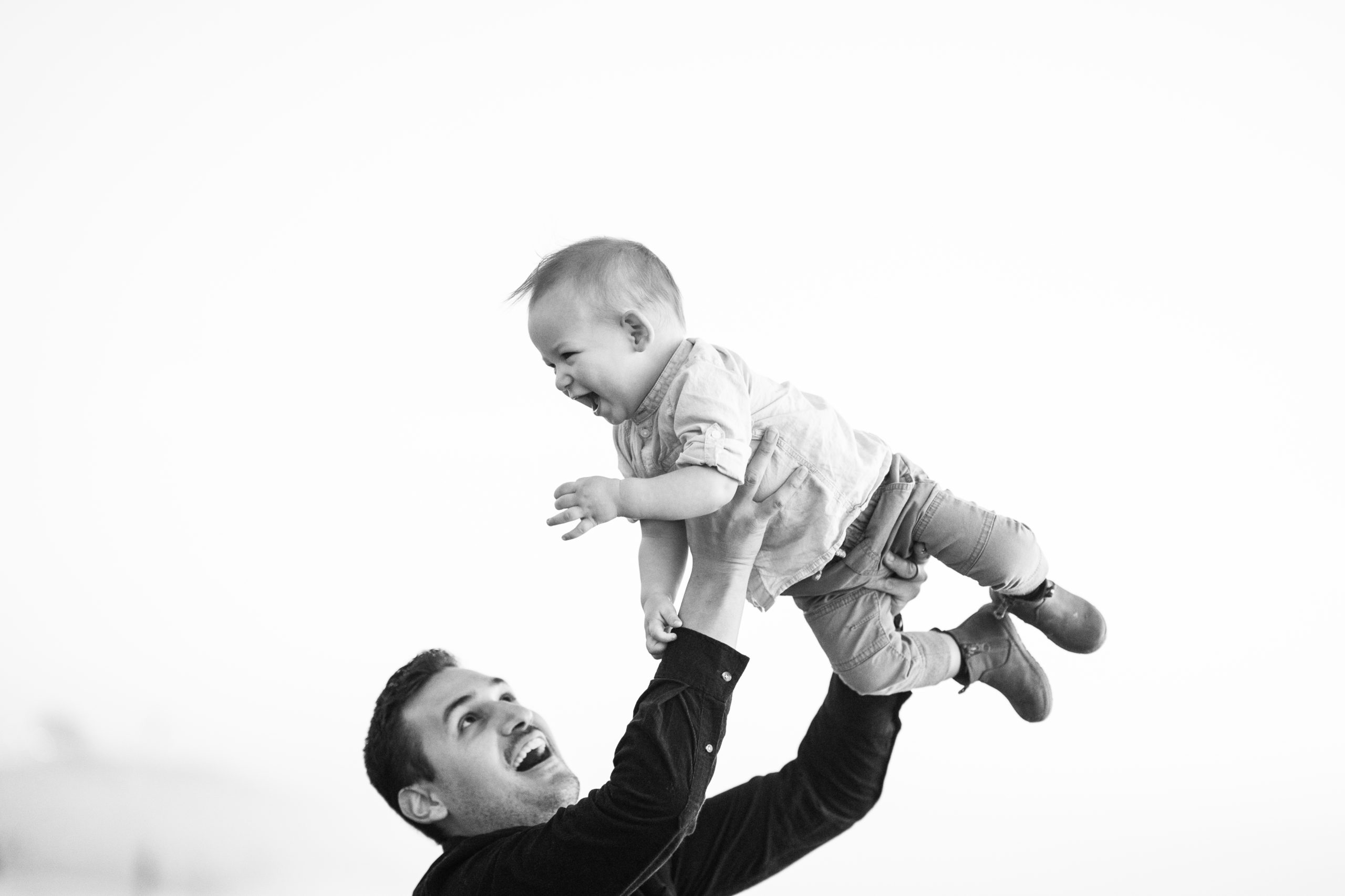 black and white father and son playing at the beach